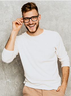 man smiling holding eyeglasses